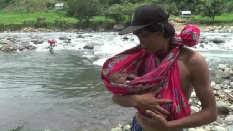 Tidak Ada Jembatan, Suami Istri Seberangi Sungai Berarus Deras Sambil Gendong Bayi