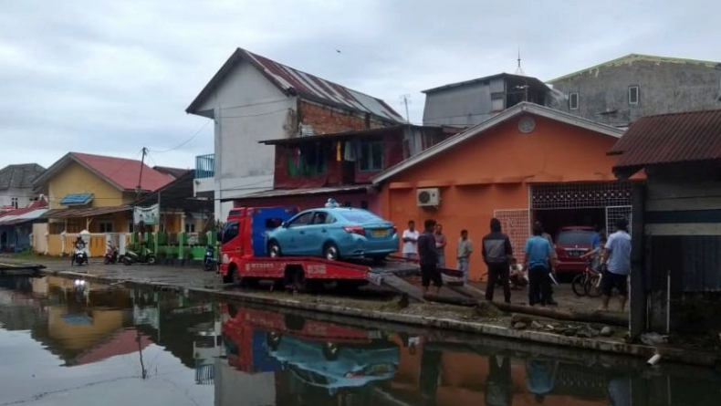 Gegara Air Meluap ke Jalan, Taksi di Padang Masuk ke Kali