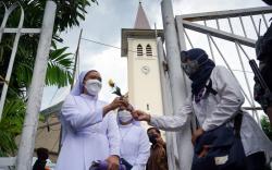 Forum Rakyat Bersatu Bagikan Bunga kepada Jemaat Gereja Katedral Makassar