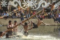 Potret Lomba Panjat Pinang Miring di Kolam Retensi