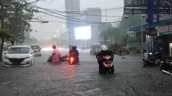 Sejumlah pengendara sepeda motor terjebak banjir di Kota Surabaya akibat hujan deras, Rabu (15/1/2020). (Foto: iNews.id/Ihya` Ulumuddin)