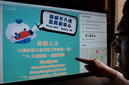 Ilustrasi foto memperlihatkan seorang lelaki menunjuk ke sebuah halaman web dari akun Facebook Kementerian Luar Negeri Taiwan, yang digunakan untuk mempromosikan pencegahan virus korona. (FOTO: Sam Yeh / AFP)