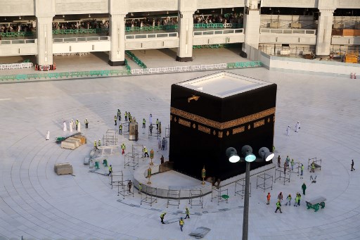 Pekerja berada di daerah ubin putih kosong yang mengelilingi Ka`bah, di dalam Masjidil Haram. (FOTO: ABDEL GHANI BASHIR / AFP)
