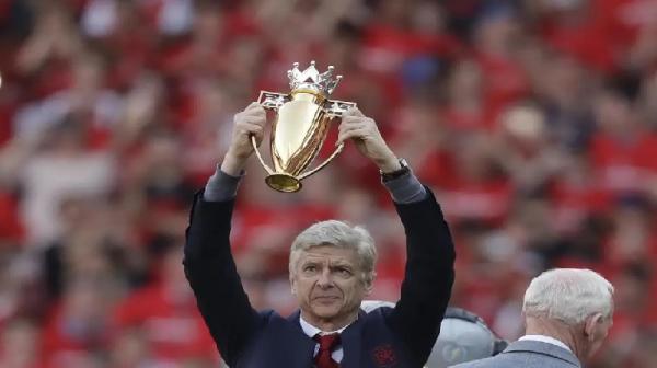 Arsene Wenger Invicibles Arsene Wenger mengangkat trofi berlapis emas saat Arsenal juara Premier League 2003/2004 (foto: Premier League)