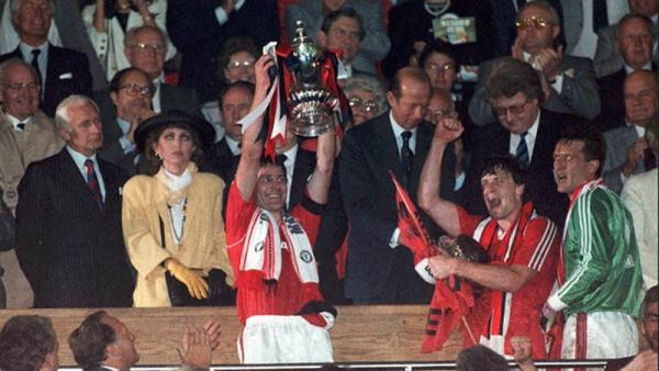 Kapten Manchester United Bryan Robson mengangkat trofi Piala FA 1990. (Foto: BT Sport)