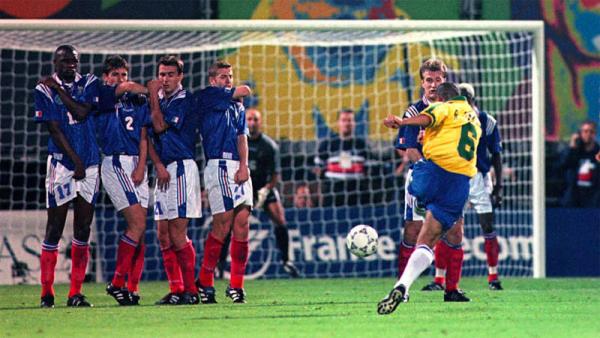 Roberto Carlos Free Kick Bek kiri Timnas Brasil Roberto Carlos melepaskan tendangan melengkung ke gawang Prancis pada Tournoi de France tahun 1997. (Foto: ESPN)