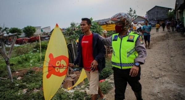 Polisi membina warga yang menerbangkan layangan Polisi membina warga yang menerbangkan layangan di dekat Bandara Soetta (Foto: Antara)
