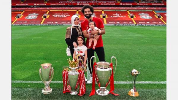 Mohamed Salah mengajak istrinya, Magi, dan kedua putri mereka, berfoto bersama empat trofi yang diraih Liverpool musim ini. (Foto: Instagram @mosalah)