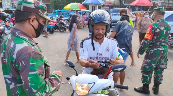 Anggota Koramil 1309-02 WTPM sosialisasi Anggota Koramil 1309-02 WTPM sosialisasikan pakai masker kepada pengendara motor, Jumat (14/8/2020) (Foto : iNews.id/Arther)