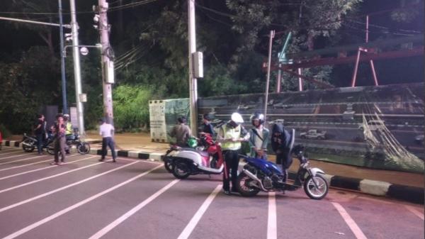 Razia Polisi Tmc Polisi membubarkan kerumunan pengendara motor di Jalan Gerbang Pemuda Senayan, Jakarta Selatan, Sabtu (22/8/2020) dini hari ini. (Foto: TMC Polda Metro).