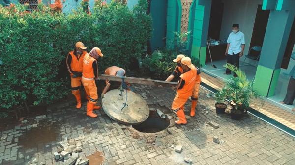Petugas PPSU membantu pembuatan drainase vertikal di musala warga. (Foto: Pemprov DKI Jakarta)