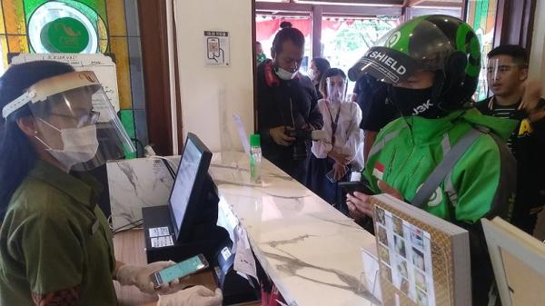 GOJEK2.JPG Merchant Go Food Resto Gama Ikan Bakar dan Seafood melakukan pelayanan kepada mitra driver. (Foto: Arif Budianto)