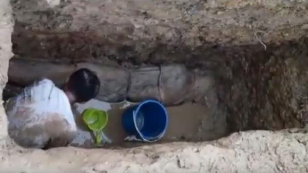 jasad kiai masih utuh di sampang Santri menguras air di makam jasad KH Ahmad Baidowi yang ditemukan masih utuh di Sampang, Madura, Jatim. (Foto: Istimewa/iNews/Tikno Arie)