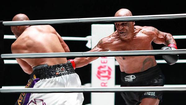Mike Tyson (kanan) melepaskan pukulan ke arah perut Roy Jones Jr pada pertandingan di Staples Center, Los Angeles, Amerika Serikat (AS), Minggu (29/11/2020) siang WIB. (Foto: REUTERS)