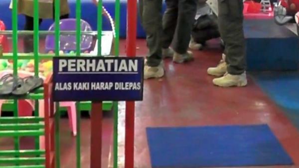 Petugas gabungan prokes di Pasaman, Sumbar masuk ke area bermain anak dengan mengenakan sepatu  (Wahyu Sikumbang/iNews)