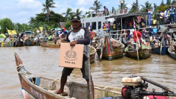 Komando Lintas Laut Militer (Kolinlamil) Jakarta memberikan bantuan kepada warga pesisir dan nelayan yang merasakan dampak wabah virus corona (Covid 19) di wilayah Perairan Muara Gembong, Kabupaten Bekasi, Selasa (19/5/2020). (Foto: Kolinlamil).