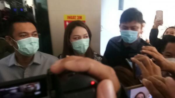 Anggota DPRD Sulut James Arthur Kojongian mendampingi istrinya Michaela Elsiana Paruntu usai diklarifikasi BK DPRD Sulut terkait video viral perselingkuhannya, Rabu (3/2/2021). (Foto: Okezone/Subhan Sabu)