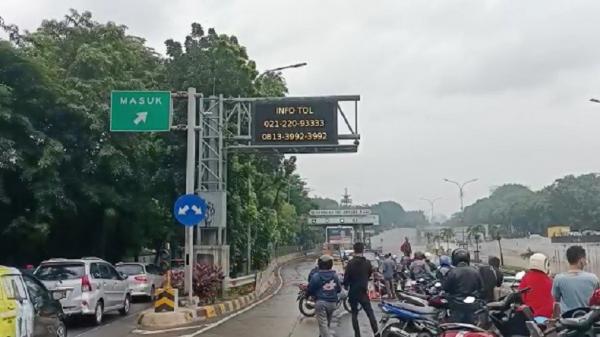 Gerbang Tol Ampea 1 Ari Si Banjir di kawasan Tol TB Simatupang, Pasar Minggu, Jakarta Selatan menyebabkan antrean panjang kendaraan, Sabtu (20/2/2021). (Foto: Ari Sandita/ Sindonews).