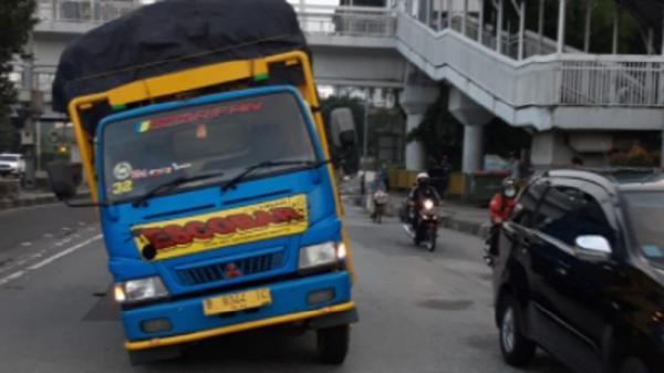 Truk penuh muatan dengan nomor polisi B 9344 IC patah as ban di depan Wisma 77, Slipi, Jakarta Barat, Selasa (23/2/2021). (Foto: TMC Polda Metro)..