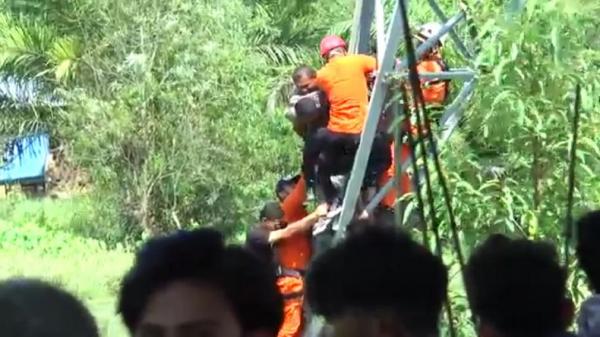 Tim Basarnas mengevakuasi oknum ASN yang memanjat tower setinggi 50 meter di kawasan Ceukok Marek, Blang Beurandang, Meulaboh, Kamis (11/3/2021). (Foto: iNews/Afsah)