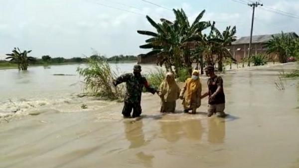 banjir gresik1 Anggota BPBD dan TNI membantu warga di lokasi banjir di kawasan Kecamatan Balongpanggang, Kabupaten Gresik, Jatim, Senin (15/3/2021). (Foto: SINDOnews/Ashadi Iksan)