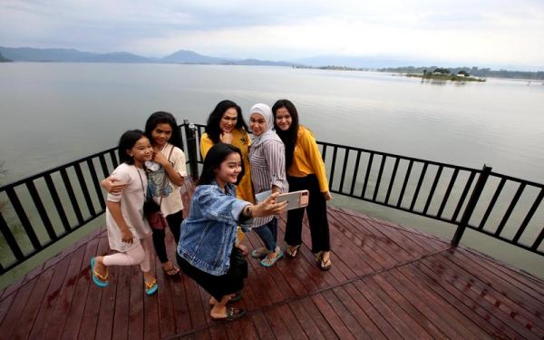 WADUK JATIGEDE Pengunjung berswafoto di kawasan wisata Waduk Jatigede. (Foto: Istimewa)