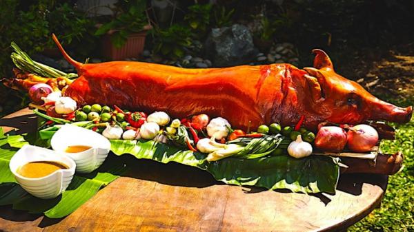 Lechon atau babi panggang yang disajikan utuh bersama bumbu menjadi makanan paling populer saat perayaan Natal di Filipina. (Foto: Istimewa).