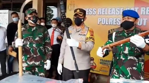Kapolres Garut AKBP Adi Benny Cahyono (tengah), Dandim 0611/Garut Letkol Inf CZI Deni Iskandar MTr (Han), dan Dandenpom III/Garut Letkol CPM Imran Ilyas menunjukkan senjata tajam yang disita dari tersangka Dadang Buaya. (Foto: iNews/Ii Solihin)