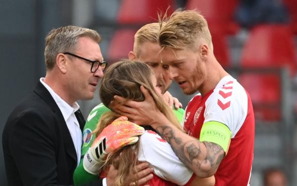 Kapten Timnas Denmark sekaligus bek AC Milan Simon Kjaer menenangkan kekasih Christian Eriksen. (Foto: Reuters)