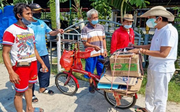 ARIF & DEDI MULYADI1 Arif menunjukkan sepeda yang digunakannya untuk memulung kardus. Di sepeda itu terdapat kotak untuk menabung uang. Setelah terkumpul, uang itu dipakai untuk membeli hewan kurban. (Foto: istimewa)