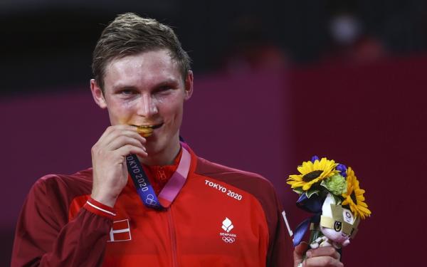 Menggigit medali emas. Itulah perayaan mini yang dilakukan pebulu tangkis tunggal putra, Viktor Axelsen, dalam Olimpiade Tokyo 2020 di Musashino FSP, Senin (2/8/2021). (Foto: REUTERS/Leonhard Foeger)