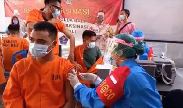 Tahanan Polda Bali menjalani vaksinasi dengan tangan tetap diborgol di Polres Gianyar, Jumat (6/8/2021). (Foto: iNews/Ketut Catur)