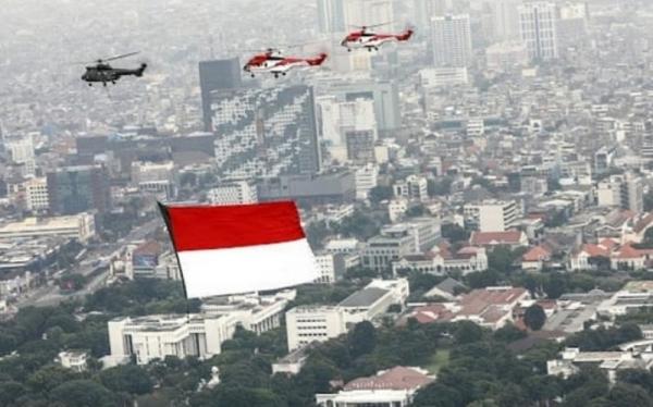 Helikopter TNI AU membentangkan bendera Merah Putih dalam rangka memeriahkan upacara HUT ke-76 RI yang digelar di halaman Istana Merdeka, Jakarta hari ini, Selasa (17/8/2021). (Foto: Dinas Penerangan TNI AU)