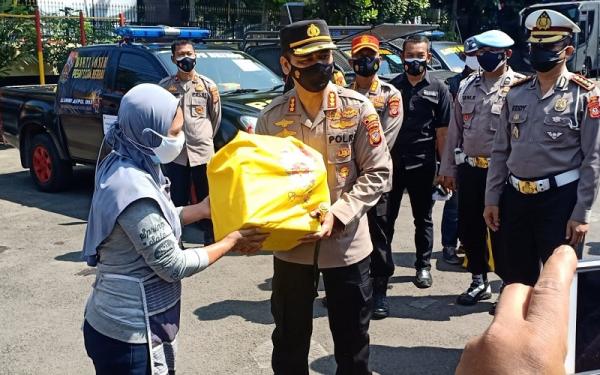 SEMBAKO AKPOL 931 Kapolrestabes Bandung Kombes Pol Aswin Sipayung yang merupakan alumnus Akpol 93 memberikan paket sembako kepada PKL. (Foto: iNews.id/Agus Warsudi)
