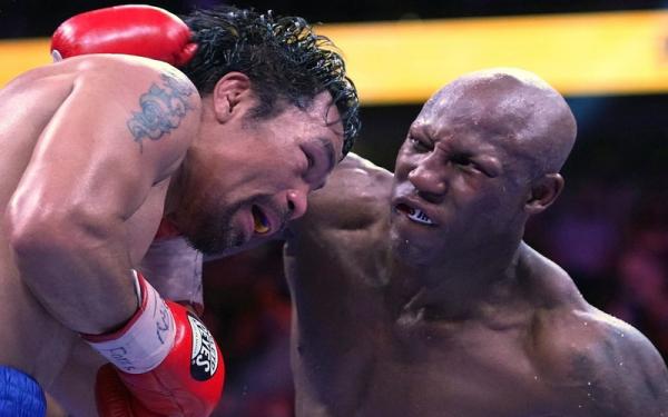 Yordenis Ugasin melepaskan pukulan ke wajah Manny Pacquiao di kelas welterweight di T-Mobile Arena, Las Vegas, AS, pada Minggu (22/8/2021) siang WIB. (Foto: REUTERS/Stephen R/ Sylvanie)