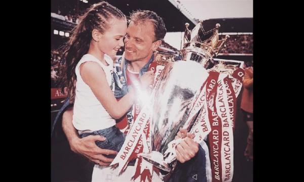 Estelle Bergkamp bersama Dennis Bergkamp Dennis Bergkamp mengajak Estelle ke tengah lapangan saat Arsenal meraih trofi Liga Inggris. (foto: The Sun)