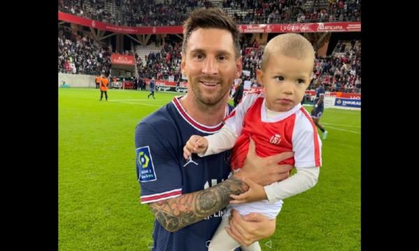 Lionel Messi foto bareng anak kiper Reims Anak Kiper Reims Predrag Rajkovic berfoto bareng Lionel Messi. Messi baru saja melakoni debut bersama PSG di Liga Prancis (foto: Twitter/BTSport)