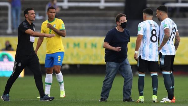 Brazil vs argentina Dua pemain Argentina Nicolas Otamendi, Marcos Acuna sedang berbicara dengan seorang anggota otoritas kesehatan Brazil dalam pertandingan kualifikasi Piala Dunia 2022 zona Amerika selatan. REUTERS/AMANDA PEROBELLI