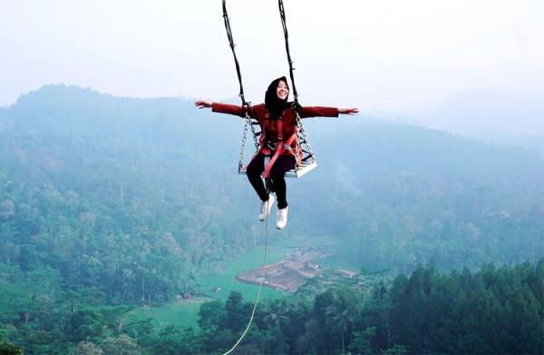Ayunan Langit Watu Jaran Wisatawan menikmati ayunan di atas Perbukitan Menoreh. (Foto: Dinpar Kulonprogo)
