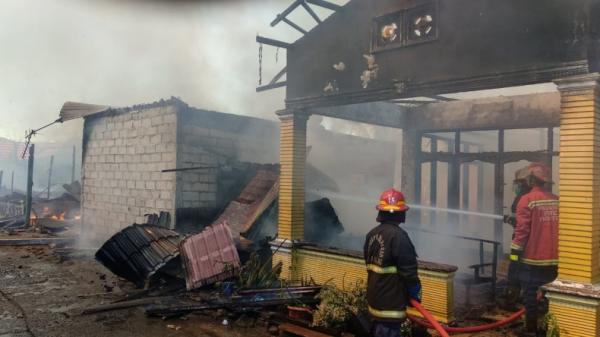 kebakaran Petugas damkar memdamkan api yang membakar lima rumah di Padang, Sumbar (Rus Akbar/MNC Portal)