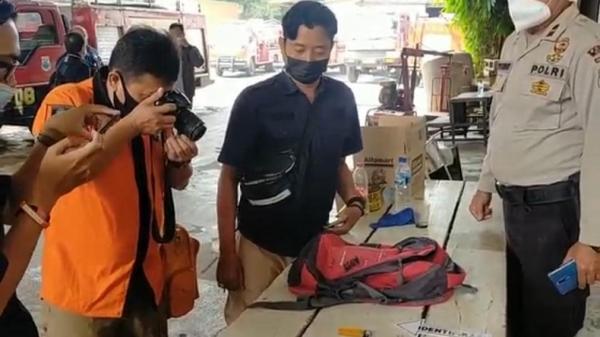 TAKSI TERBAKAR CIMAHI Petugas Inafis Polres Cimahi mendokumentasikan barang bukti korek api gas, tas merah, dan botol berisi siswa pertalite yang diduga milik tersangka AK. (FOTO: iNews/YUWONO WAHYU)