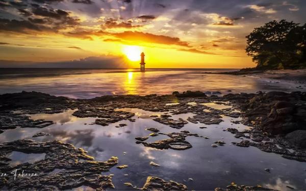 Pantai di Pantai Senggigi dengan mercusuarnya menjelang malam hari. (Foto: Antara/Riza Fahriza)