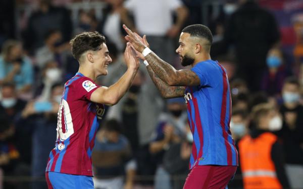 Penyerang Barcelona, Memphis Depay (kanan) merayakan gol ke gawang Valencia bersama Gavi dalam laga Liga Spanyol 2021/2022 di Stadion Camp Nou, Senin (18/10/2021). (Foto: REUTERS/Albert Gea)