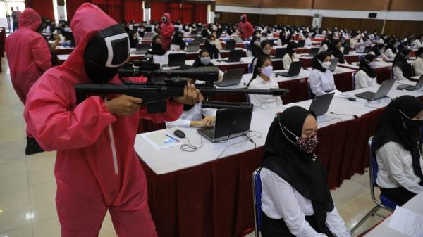 Para peserta tes CPNS Kemenkumham Jawa Timur (Jatim) dikawal dan diawasi oleh panitia yang berdandan ala pink soldier dalam film seri Squid Game.  (Foto: Kemenkumham Jatim)