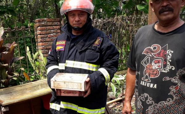 kebakaran Petugas membawa 2 alquran yang selamat dari kebakaran, Selasa (26/10/2021). (Foto: iNews.id/Avirista Midaada).