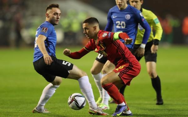 Kapten Timnas Belgia, Eden Hazard Kapten Timnas Belgia, Eden Hazard (merah) berusaha mengecoh pemain Estonia dalam laga Kualifikasi Piala Dunia 2022 di Stadion King Baudouin, Minggu (14/11/2021). (Foto: REUTERS/Pascal Rossignol)