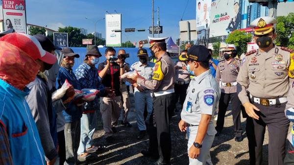 Dirlantas Polda Jabar Kombes Pol Eddy Djunaedi membagikan sembako kepada warga terdampak pandemi di sela kegiatan Operasi Zebra Lodaya 2021. (Foto: Humas Polda Jabar)