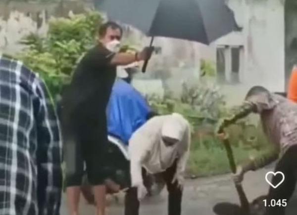 Tangkapan layar dari video yang beredar di medsos saat Mensos Risma mengais batu dna pasir untuk menutup jalan berlobang. (Foto : Ist)
