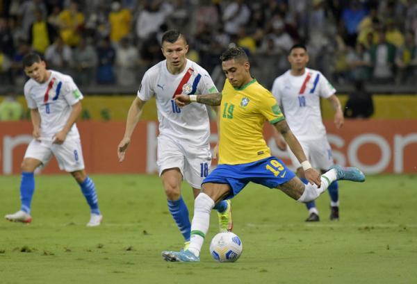 Winger Timnas Brasil, Raphinha (19) hendak melepaskan tembakan saat dikawal pemain Paraguay, Braian Samudio pada laga Kualifikasi Piala Dunia 2022 zona CONMEBOL di Stadion Belo Horizonte, Rabu (2/2/2022). (Foto: REUTERS/Washington Alves)
