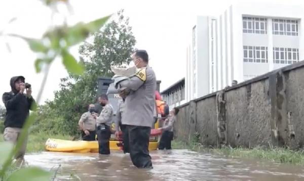Gendong Bayi 1 Kapolres Singkawang AKBP Prasetiyo Adhi Wibowo mengevakuasi korban banjir. (Foto: iNews/Uun Yuniar).